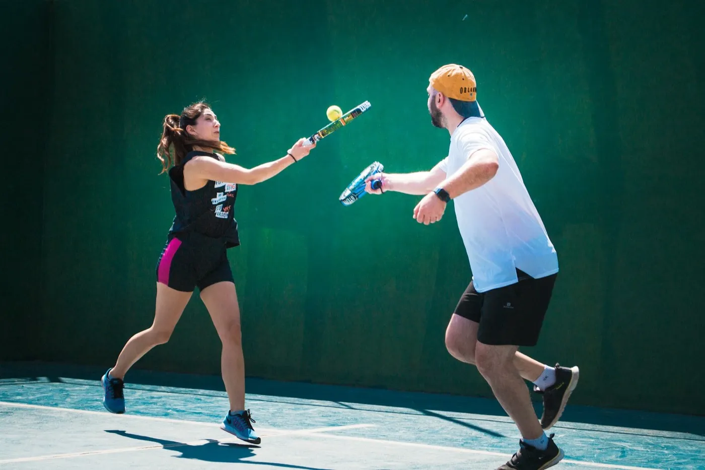 Two players contesting a point on an outdoor padel court